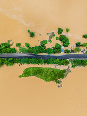 Overhead aerial of flood disaster—muddy water drowns roads, homes, and fields.