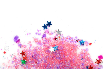 Close up of confetti tinsel glitter and shining stars on white background