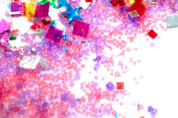 Close up of confetti tinsel glitter and shining stars on white background