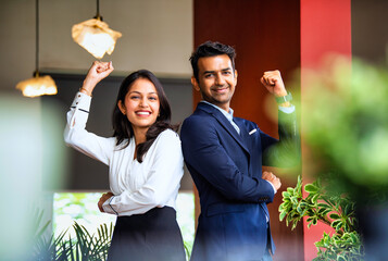 Posing with success and smiling confidently, Indian business professionals stand in office together