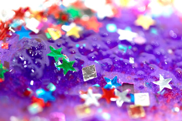 Close up of confetti tinsel glitter and shining stars on white background