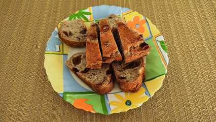 Slices of fruit bread arranged on colorful plate on placemat