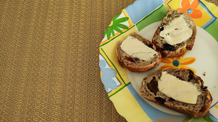 Slices of bread with butter and raisins on colorful plate for a wholesome breakfast