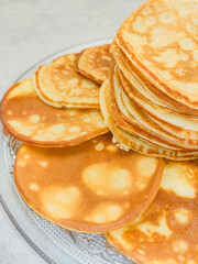 Stack of pancakes showing cooking spots on glass plate