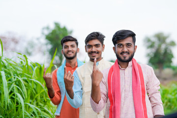 three young indian villager showing voting finger