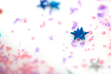Close up of confetti tinsel glitter and shining stars on white background