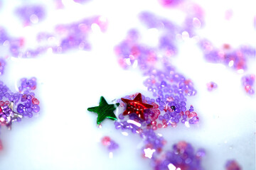 Close up of confetti tinsel glitter and shining stars on white background