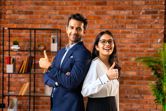 Posing with success and smiling confidently, Indian business professionals stand in office together
