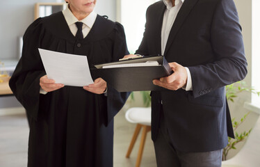 Naklejka na ściany i meble Judge woman in professional outfit black robe standing engaged in reviewing documents in court room, examination or discussion of legal and judicial settings, lawyer consultation, case preparation