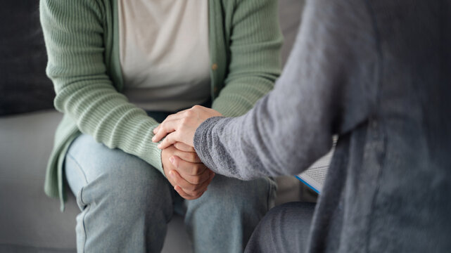 Psychologist, friend or family holding hands to encourage patient with depression, anxiety, therapy