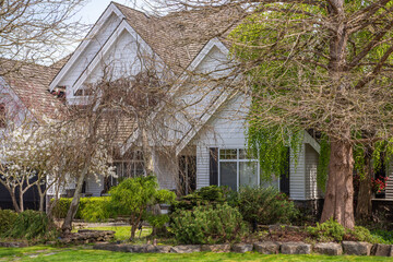Two story stucco luxury house with nice spring blossom landscape in Vancouver, Canada, North...