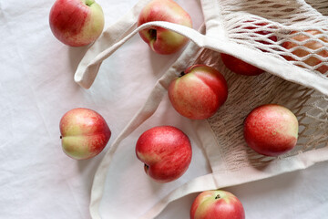 Nectarine. Ripe juicy organic nectarines (peaches) in a reusable mesh cotton shopping bag. plastic...