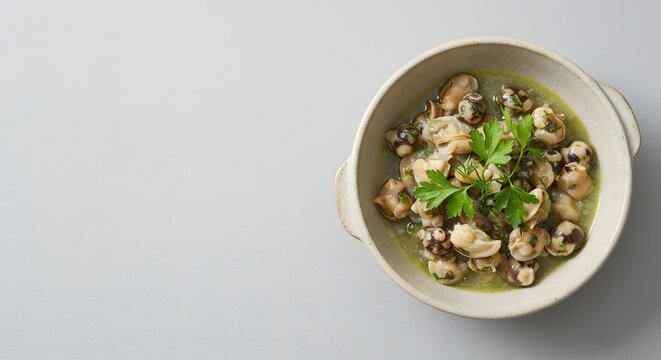 Top view of Buzio (whelk stew), ceramic bowl placed at right third, minimalist top view with fresh herbs for garnish (top view) 1