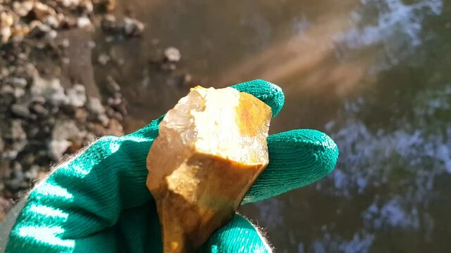 Inspection of a quartz specimen on flint found in a stream, rock and mineral search