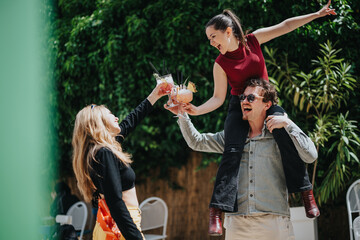 Friends share joyful moments outdoors while celebrating and enjoying drinks. Highlighting happiness, the cheerful atmosphere captures the essence of friendship and carefree leisure time.