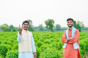 indian farmer standing together at green agricultural field