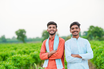 indian farmer standing together at green agricultural field