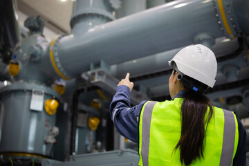 Engineer inspects gas insulated switchgear with focus and care in industrial setting ensuring...