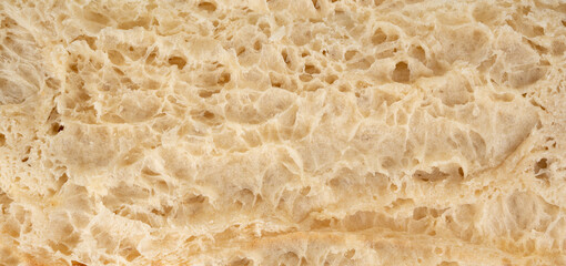Focaccia flatbread slice macro texture, baked dough pattern. White bread loaf cut close up