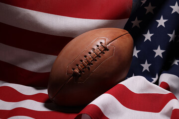 American football ball and USA flag. Sport game. Super bowl in US. Football ball Close Up macro photography with copy space.