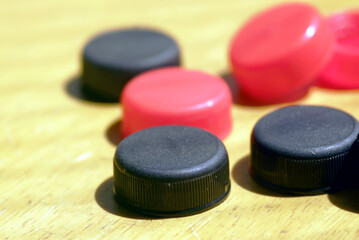 Circular economy and minimalistic approach to sustainable living: bottle lids prepared for recycling. Red and black caps symbolizing waste reuse, climate responsibility, environmental awareness
