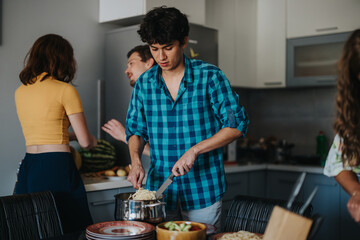 A group of young adults cooking and interacting in a modern kitchen. They share a meal preparation, highlighting friendship and culinary skills. Casual and relaxed atmosphere in a home setting.