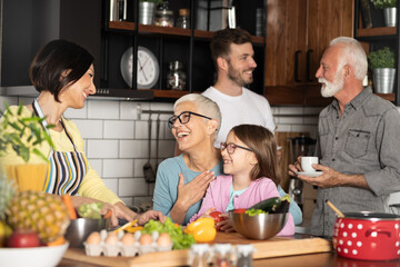 Cheerful family spending good time together while cooking in kitchen