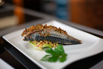 Grilled mackerel on barbecue with crispy skin and herbs, healthy seafood dish