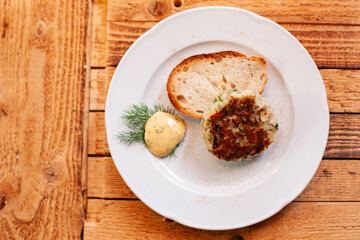 Traditional German meatball (Frikadelle) served with bread on plate, hearty home-cooked meal