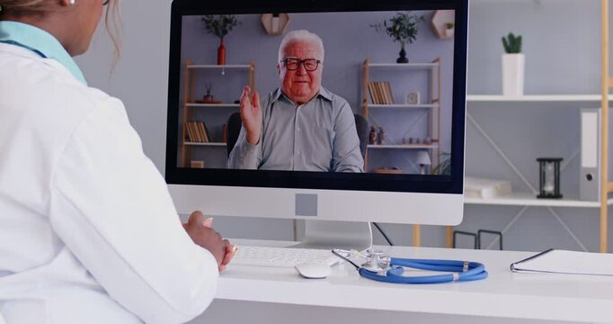 Doctor online, telemedicine, medical consultation for senior male patient, computer monitor view over female shoulder, giving help via internet for distant communication and health protection, support