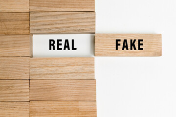 real and fake words text on wooden blocks isolated on white background