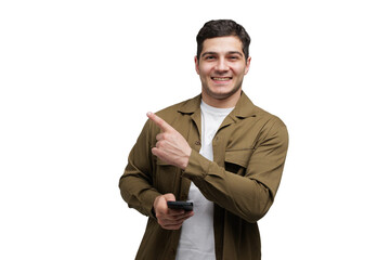 Young man joyfully pointing while holding a smartphone against a clean white background during 