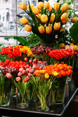 A close-up view of numerous colorful wooden tulips displayed for sale, showcasing vibrant hues