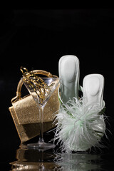 Fashion still life with feather-trimmed white heels, a shimmering gold purse, and a champagne glass-symbolizing upscale style, glamor, and modern elegance.