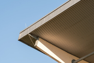 Corrugated metal roof with wooden support beams and clear blue sky