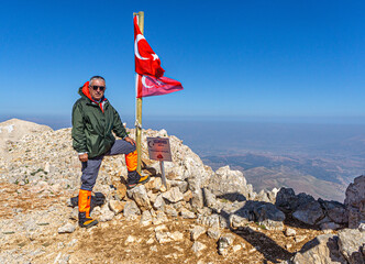 Hiker is posing at the summit of Kızlar Sivrisi Mountain (3070 m.) at Elmalı, Antalya, Turkey