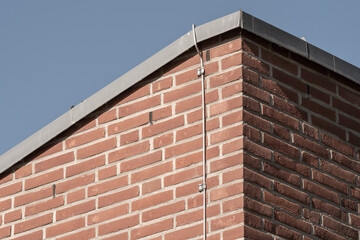Lightning rod cable running down brick wall of building