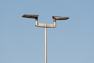 Modern street light illuminating the night against a clear blue sky