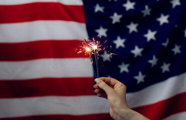 Woman holding Sparklers on American Flag background. Independence day United States. Celebration...