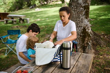 Mother and Children Enjoying a Casual Picnic Outdoors in a Serene Park Setting