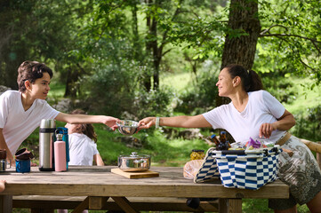 Family Enjoying Outdoor Picnic in Scenic Park Setting During Sunny Day