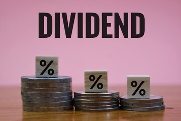 Financial Dividend Concept with Percentage Cubes and Coins on pink Background