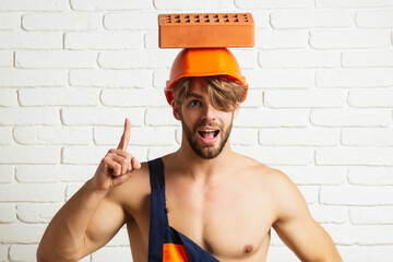 Crazy builder with bricks, funny sale on construction site. Funny man with helmet doing brick work....