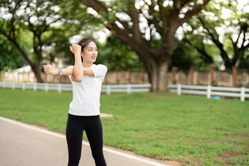 Dynamic Stretching. Young woman stretching arms outdoors in park.