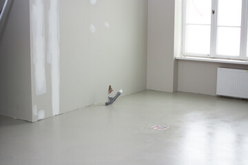 Freshly poured concrete floor in a future restaurant kitchen with unpainted walls during renovation