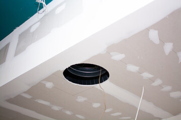 Suspended ceiling in a restaurant with holes showing large ventilation pipes, ceiling unfinished