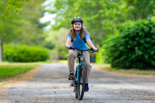 Child bike ride. Child biking down summer road. Kid riding bicycle with smile. Kid cycling. Kid ride on bike. Happy boy on bike. Kid biking outdoors. Children biking. Little biker. - Powered by Adobe