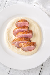 Sliced Fried Duck Breast Served with Mashed Potatoes on White Dinner Plate