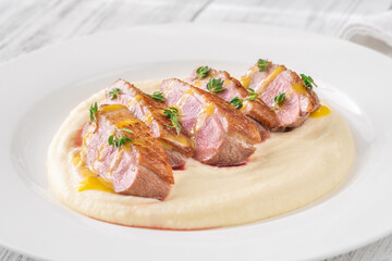 Sliced Duck Breast with Sauce and Thyme on Mashed Potato Bed