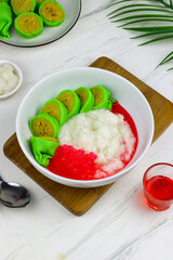 Es Pisang Ijo or Green banana ice, one of Indonesian popular dessert from east Sulawesi, Makassar. Es Pisang ijo made from banana coated with green flour dough, serve with red syrup.